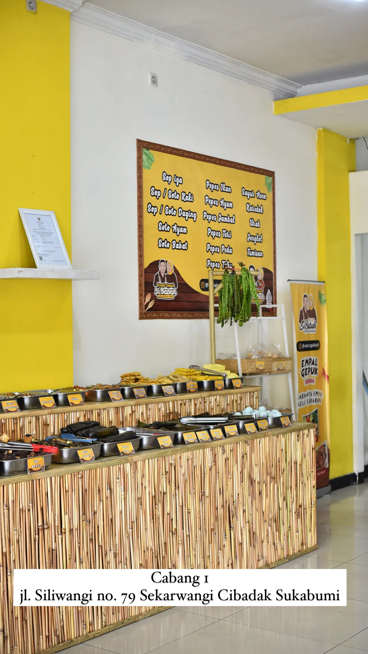 Meja prasmanan cabang Cibadak dengan papan menu di dinding